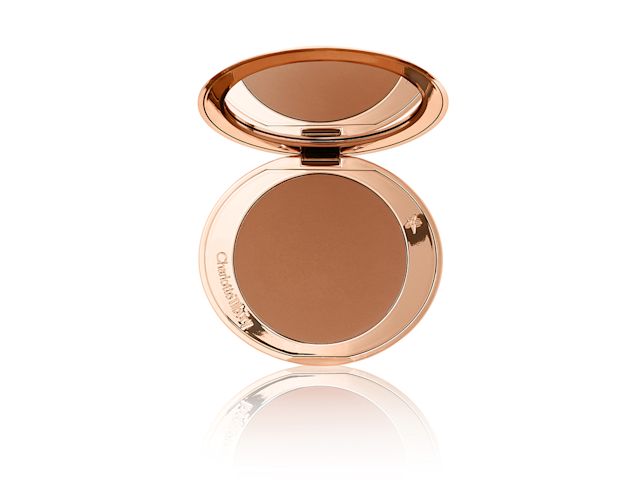 An open bronzer compact with a mirrored-lid in a medium-brown shade with gold packaging.