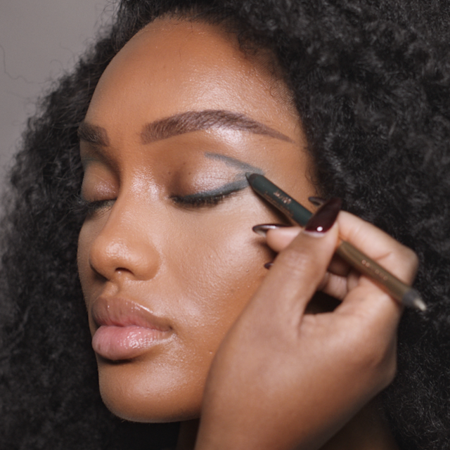 Step 3 in Charlotte's 70s makeup tutorial is creating a v shape with green eyeliner