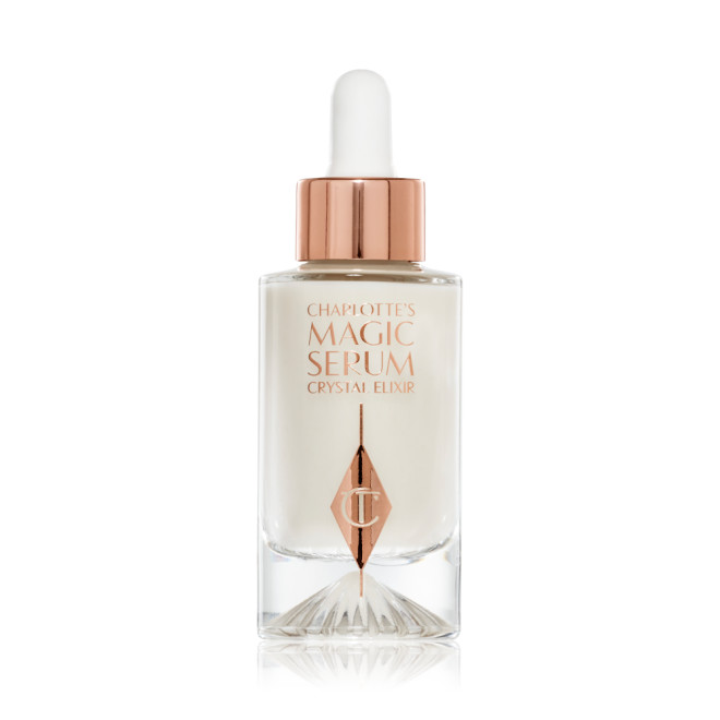 Crystal Magic Serum in a clear, glass bottle with a glass dropper in rose-gold packaging. 					