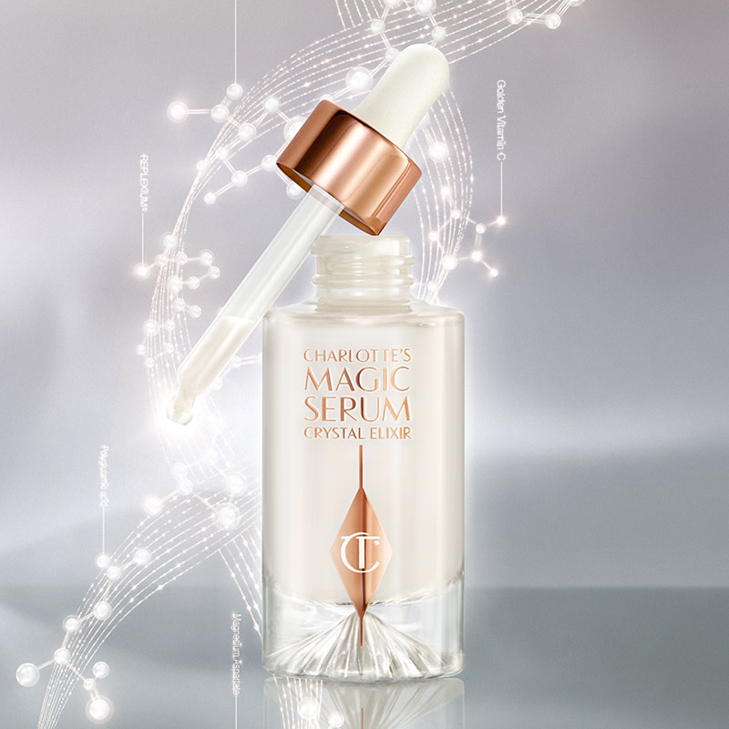 An open, pearly-white face serum in a glass bottle with a dropper applicator, in white and rose gold colour scheme. 