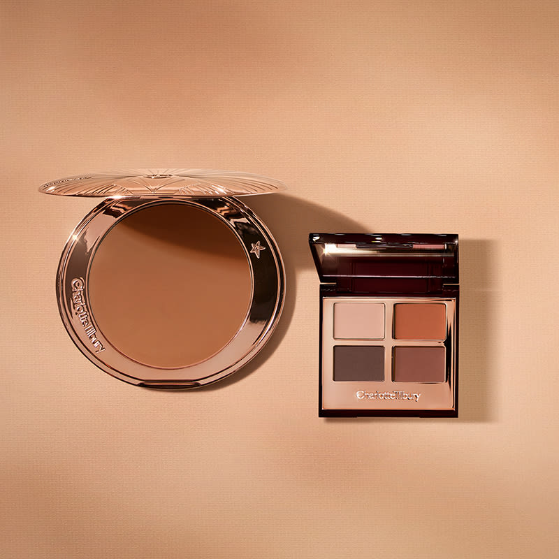 An open bronzer in medium-brown shade in golden-coloured compacts with an open, mirrored lid eye shadow palette with four matte and shimmery eye shadows in shades of brown and champagne.