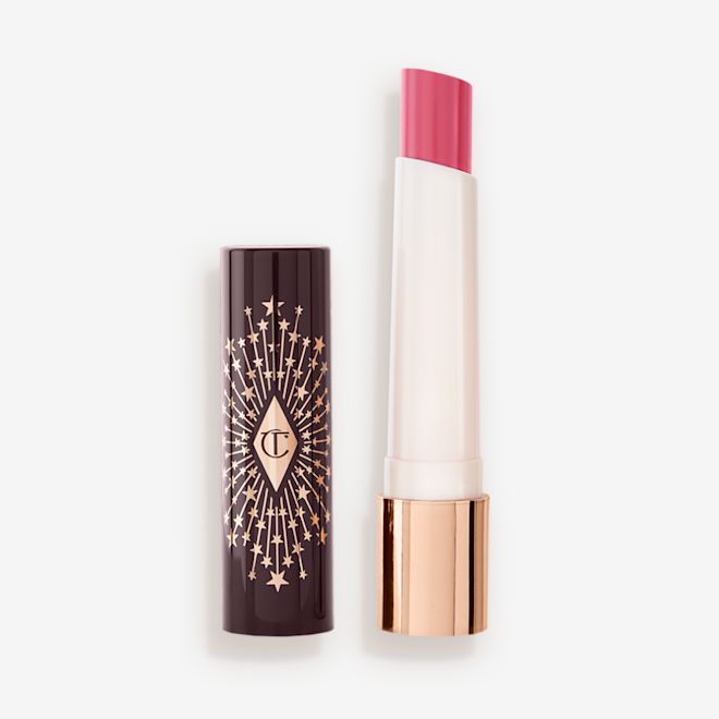 Hyaluronic Happikiss in Crystal Happkiss lid removed An open lipstick lip balm in a sheer nude pink berry shade, in white and gold tube with a black-coloured lid with gold sparkles all over it.