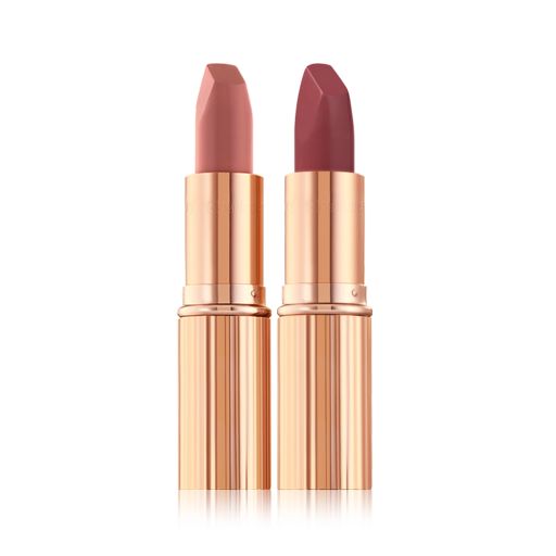 Two matte lipsticks, one a nude pink and the other a berry-rose shade in golden, metallic tubes with their lids removed. 