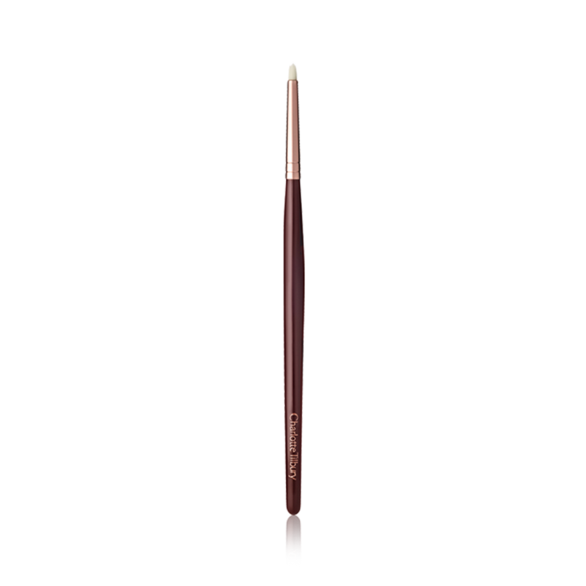 A slim eyeshadow brush with white-coloured bristles with a rose-gold and dark crimson handle. 