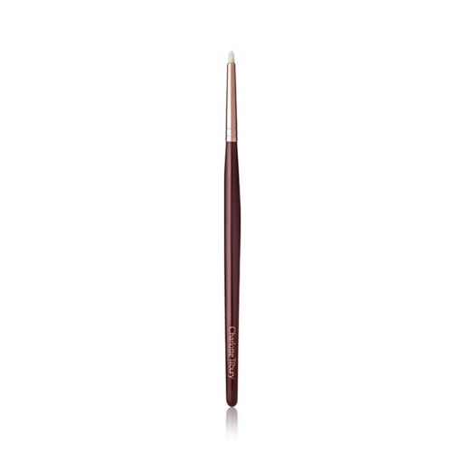 A slim eyeshadow brush with white-coloured bristles with a rose-gold and dark crimson handle. 