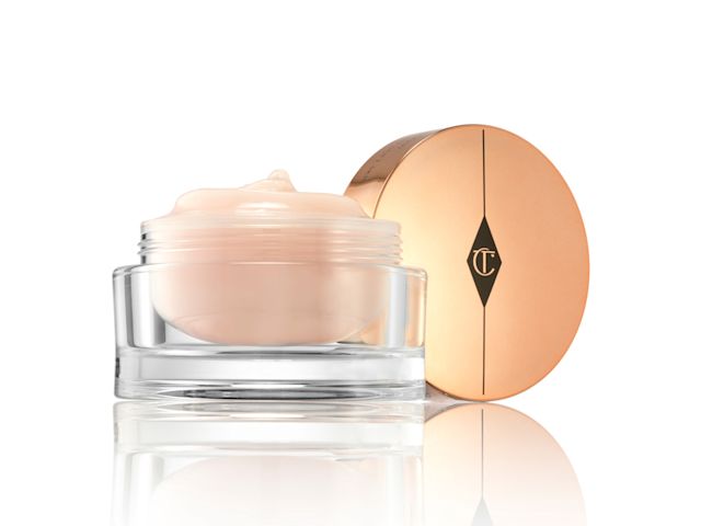 An open, three-in-one, champagne-coloured cleansing balm in a glass jar with a golden-coloured lid. 