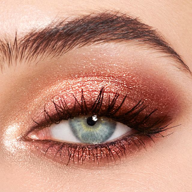 Gros plan sur l’œil d'un mannequin portant un maquillage des yeux rose scintillant avec Pillow Talk Palette of Pops