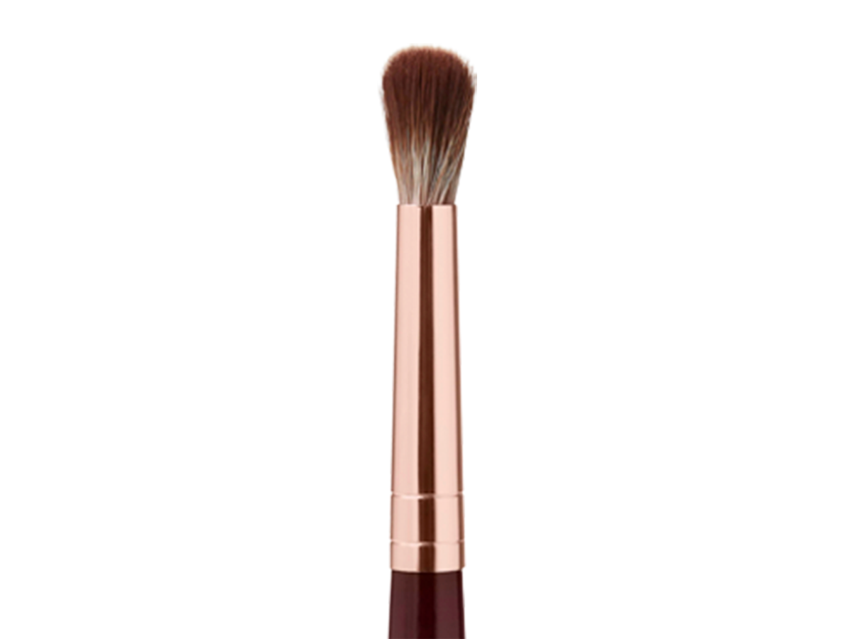 An eyeshadow blending brush in a rose gold and dark crimson colour scheme. 