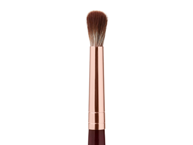 An eyeshadow blending brush in a rose gold and dark crimson colour scheme. 