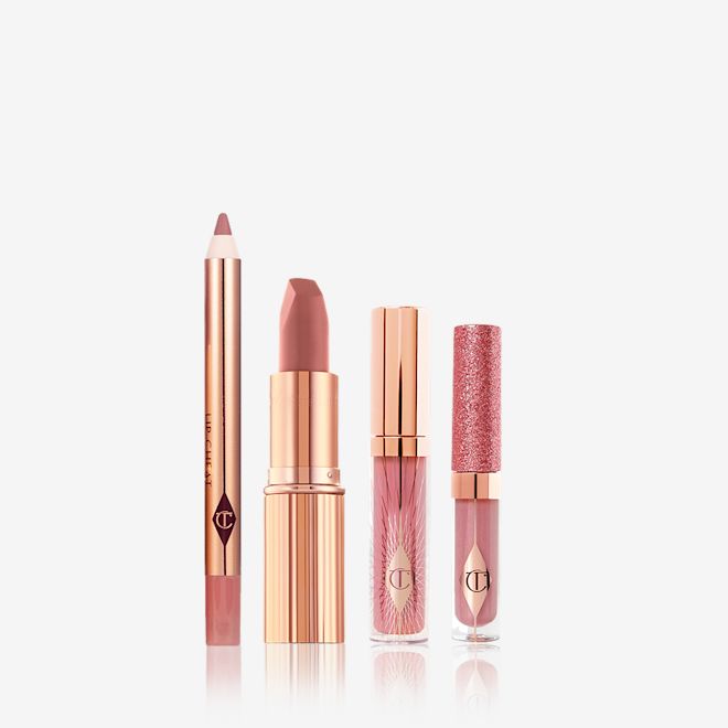 Pillow Talk Lip Secrets Kit displayed An open lip liner pencil, open nude pink matte lipstick, nude pink lip gloss in a glass tube with a gold-coloured lid, and shimmery nude pink lip gloss in a glass tube with a glittery lid.