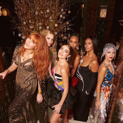 Maroon-coloured banner with Charlotte Tilbury along with different models wearing flawless and glowy makeup at the British Fashion awards.