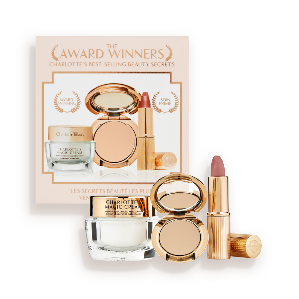 Pearly-white face cream in a glass jar with a gold-coloured lid, pressed powder compact in a medium-shade, and a dusky pink lipstick in a sleek gold-coloured tube.