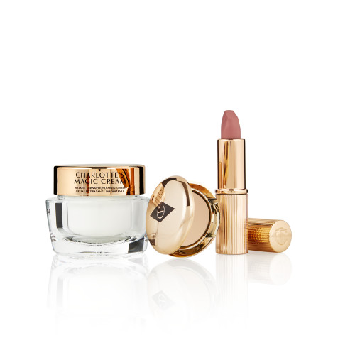 Pearly-white face cream in a glass jar with a gold-coloured lid, pressed powder compact in a medium-shade, and a dusky pink lipstick in a sleek gold-coloured tube.