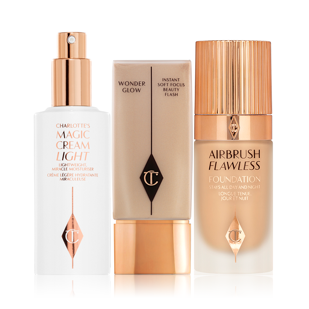 A face cream in a white-coloured bottle with a pump dispenser and two foundations, one a frosted glass bottle with a gold-coloured and the other in a rectangular plastic bottle with a gold-coloured lid. 