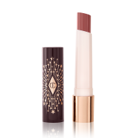 An open, moisturizing lipstick lip balm in a nude pink shade with a black and gold-coloured cover. 