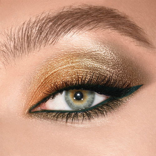 Eye close-up of a light skin model with green eyes wearing shimmery green and khaki eye makeup.  