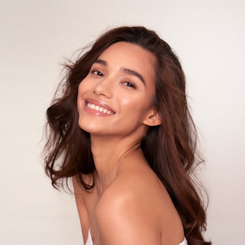 Medium-tone brunette model with glowy, flawless, and moisturised skin. 
