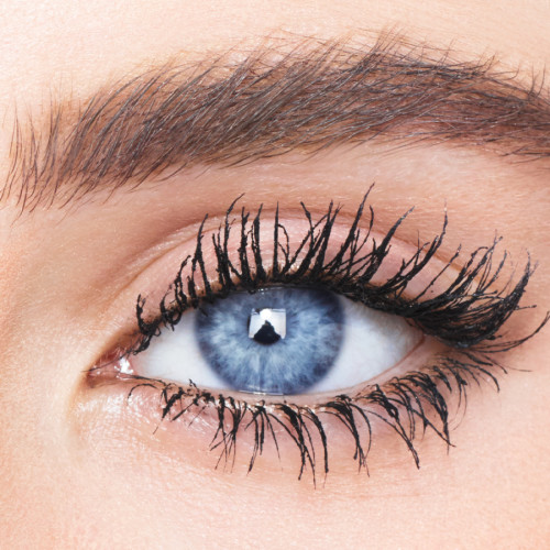 Single-eye close-up of a fair-tone model with blue eyes wearing jet-black lengthening and curling mascara. 