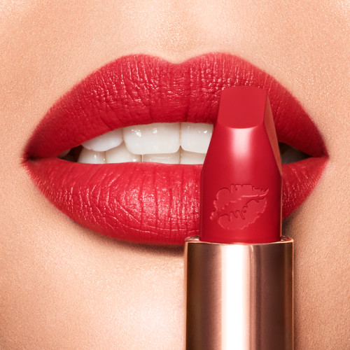 Light-tone model wearing a matte, bright cherry red lipstick. 