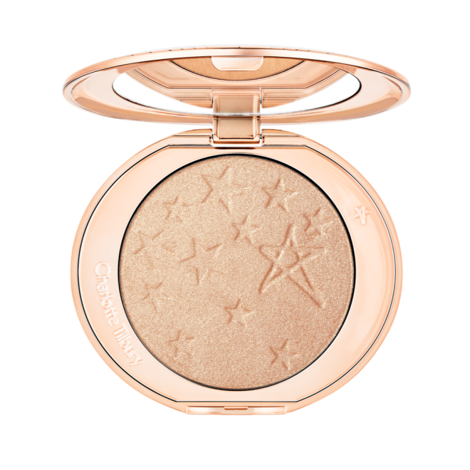 An open highlighter powder compact with a mirrored lid, in a shimmery champagne shade. 