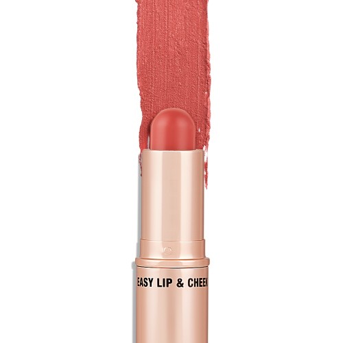 An open, lip and cheek colour stick in a glowy coral shade in a golden-coloured tube.