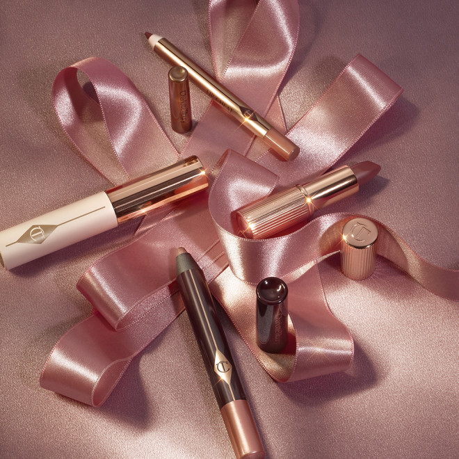 An unpacked makeup kit that includes an eyeshadow pencil in a rose gold shade, mascara, lip liner pencil in nude pink, and lipstick in a nude pink shade.