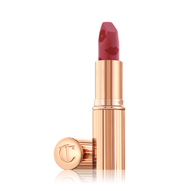Look of Love Matte Revolution Lipstick in First Dance open An open, blushed berry-rose lipstick in a metallic, golden-coloured tube with its lid next to it.
