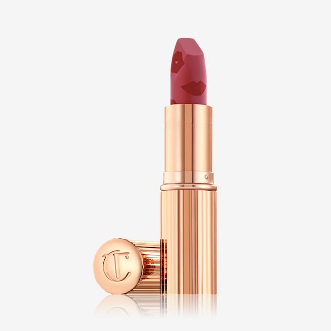 Look of Love Matte Revolution Lipstick in First Dance open An open, blushed berry-rose lipstick in a metallic, golden-coloured tube with its lid next to it.