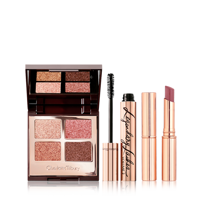 Palette of Pops in Pillow Talk, Superstar Lips in Pillow Talk, and Legendary Lashes Mascara Bundle An open, mirrored-lid quad eyeshadow palette in shimmery pink and brown shades, a mascara in golden packaging with its applicator next to it, and a berry-pink lipstick.