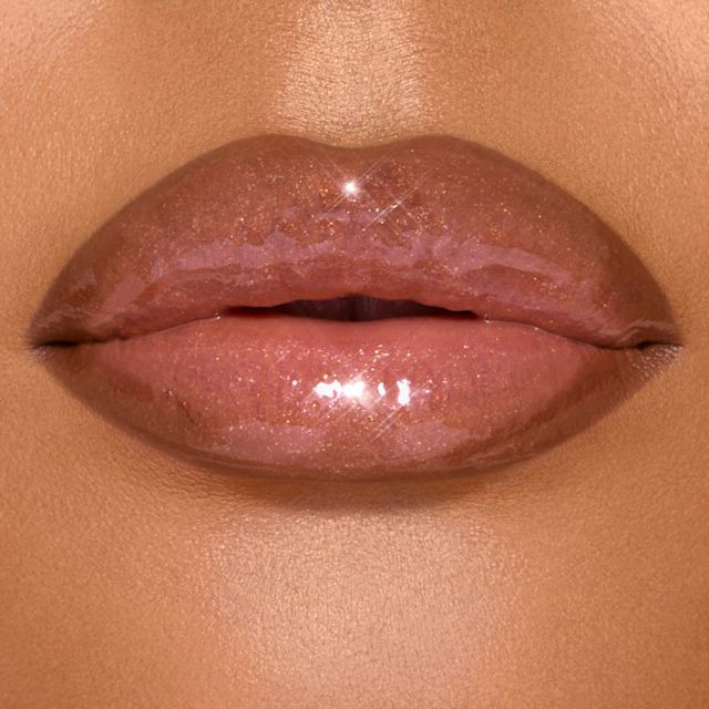 Model with tan skin wearing Lip Cheat Contour Duo and Nudegasm Diamonds lip liner and lip gloss combination