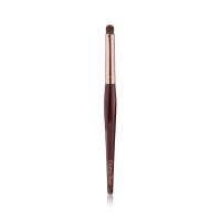 An eyeshadow smudging brush with soft bristles and rose gold and dark crimson handle. 