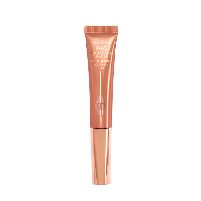 Beauty Light Wand Pillow Talk Medium A liquid highlighter wand in a coppery-gold plastic tube with its nude-pink box next to it.