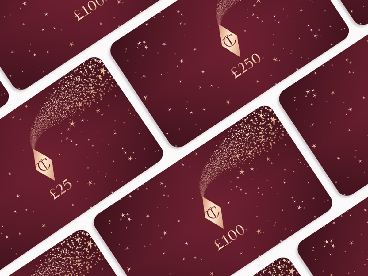 A collection of dark scarlet-coloured gift cards with gold-coloured stars printed on them with spending amount written on them in golden-colour.