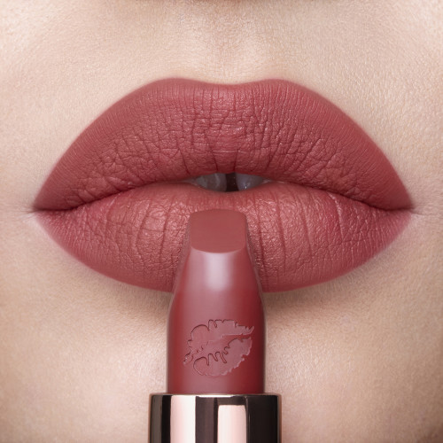Lips close-up of a fair-tone model wearing a matte lipstick in a soft, muted berry-rose colour. 