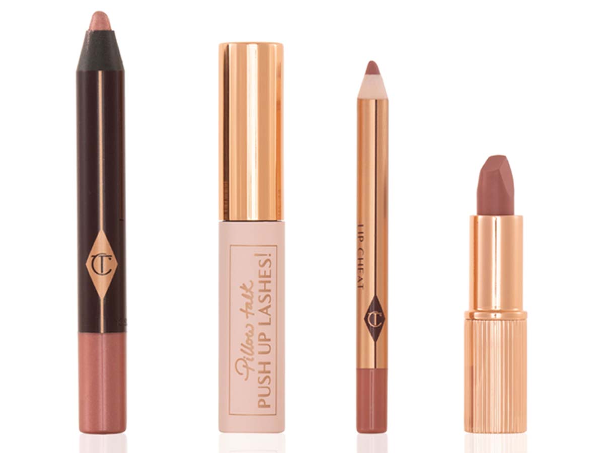 An unpacked makeup kit that includes an eyeshadow pencil in a rose gold shade, mascara, lip liner pencil in nude pink, and lipstick in a nude pink shade.