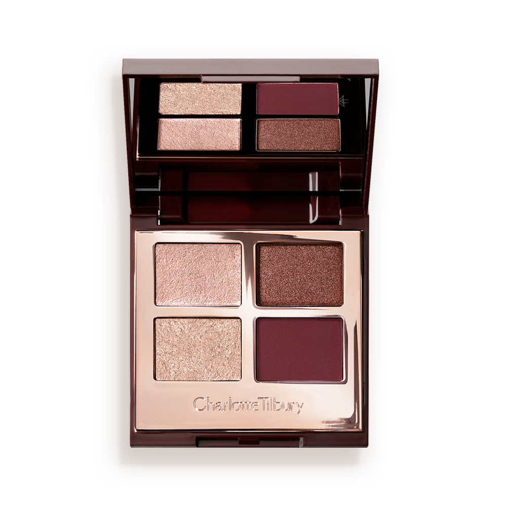 An open, mirrored-lid quad eyeshadow palette with matte and shimmery shades in maroon, dark brown, champagne, and rose gold. 