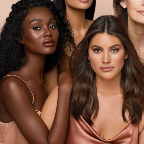 Deep-tone and medium-tone brunette model with glowy, bronzed skin wearing soft-glam nude makeup.