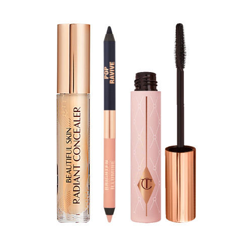 A double-sided eyeliner pencil in jet black and nude beige with an open mascara tube with its applicator next to it, and concealer in a glass tube with a gold-coloured lid with text on the tube that reads, 'Beautiful Skin Concealer'