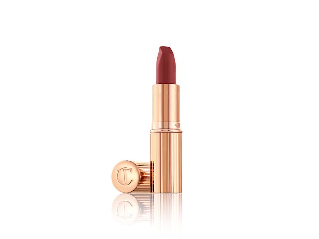   A matte lipstick in a berry-red shade with its lid next to it. 