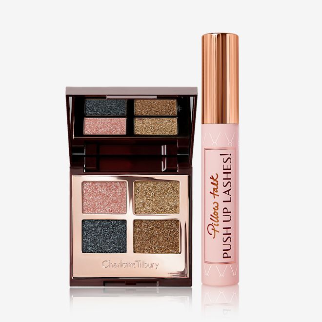 Dazzling Diamonds Eye Kit displayed An open, mirrored-lid quad eyeshadow palette in shimmery pink, blue, and gold shades with a mascara with a nude pink tube and gold-coloured lid.