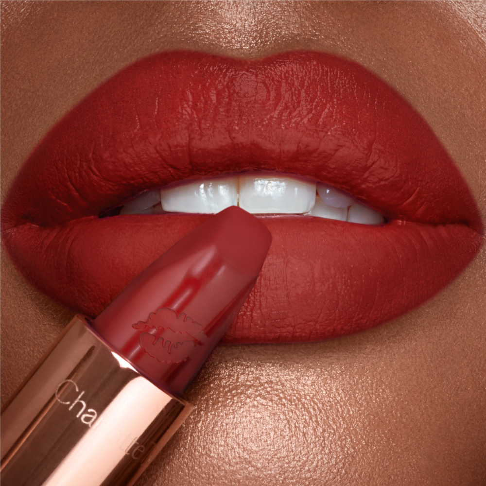 Coronation Red Lipstick on Deep skin tone model