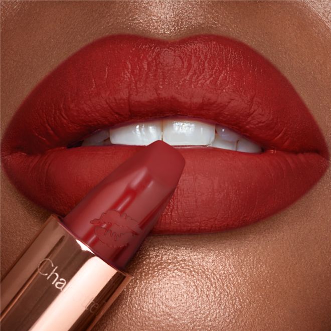 Coronation Red Lipstick on Deep skin tone model Coronation Red Lipstick on Deep skin tone model