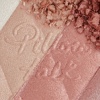 Close-up swatch of a pressed powder highlighter compact in various shades of pink and gold for cool-tone complexions. 