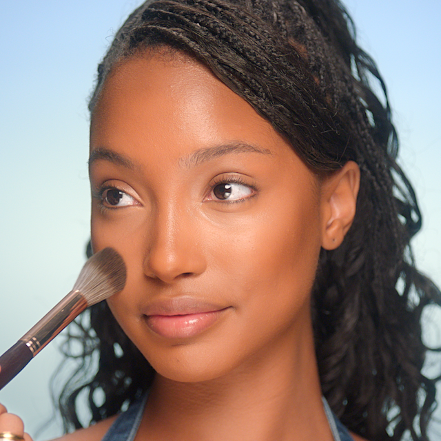 model with mattified skin having makeup powder applied to her cheek