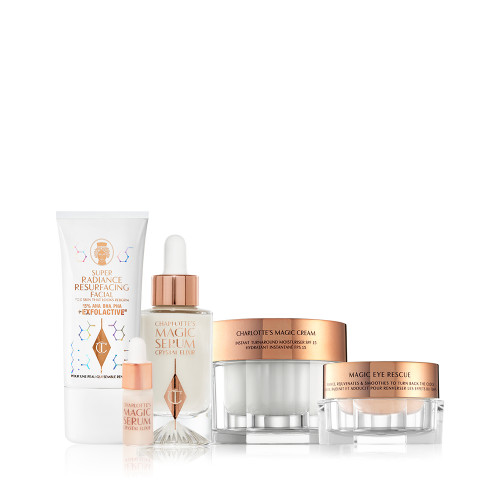 An exfoliating wash-off mask in a white-coloured tube with a luminous, ivory-coloured serum with a dropper lid, pearly-white face cream in a glass jar with a gold-coloured lid, champagne-coloured eye cream in a petite glass jar with a gold-coloured lid.