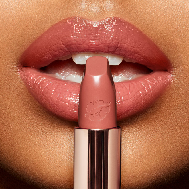 Lips close-up of a medium-tone model wearing a sumptuous pink lipstick with a moisturizing satin-finish.