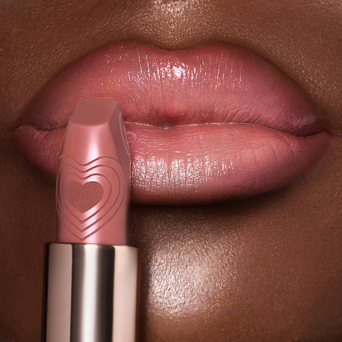 Close-up of a deep-skin model's lips wearing a blush pink lipstick with a satin finish