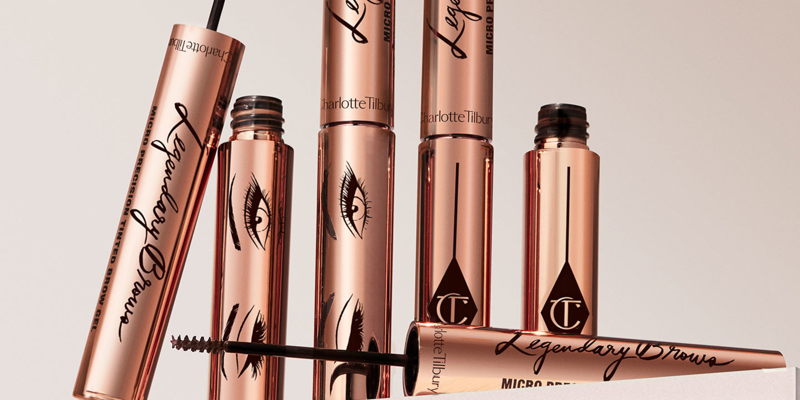 Eyebrow gels in gold-coloured tubes with thin, black-coloured brushes for precise application.