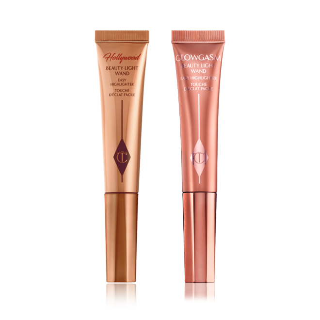 A highlighter wand and a highlighter blush wand with reflective packaging in rose gold and honey-gold shades.