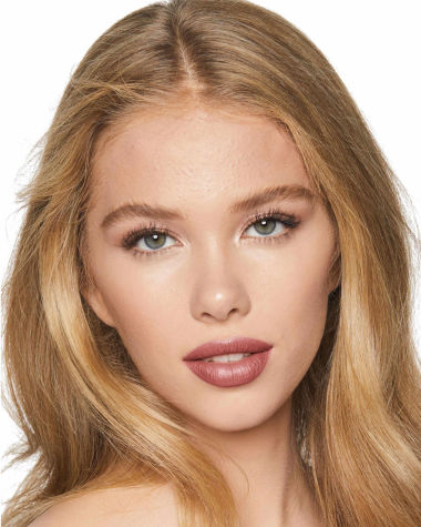 Fair-tone model with grey eyes wearing a cool, universally-flattering nude-beige lipstick with a satin-finish.